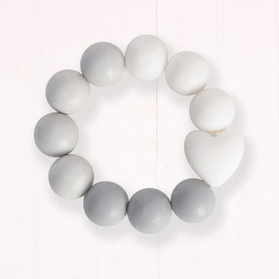 Bambino Silicone Bead Teether Grey. Introducing the Bambino Silicone Bead Teether Ring, the perfect way to help your little one deal with teething discomfort. Made from environmentally friendly silicone rubber, this durable and long-lasting teether is safe for your child from birth. The white and pastel grey round beads offer a massaging effect on your baby's gums,