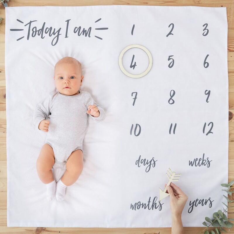 Ginger Ray Baby Milestone Keepsake Blanket. Capture all the moments of your child's first year with our Baby Milestone Blanket Keepsake. Made from a soft, cuddly  white blanket  and accented by wooden age markers to display each milestone (6-9 months, 9-12 months); it records that oh so important time when life begins.