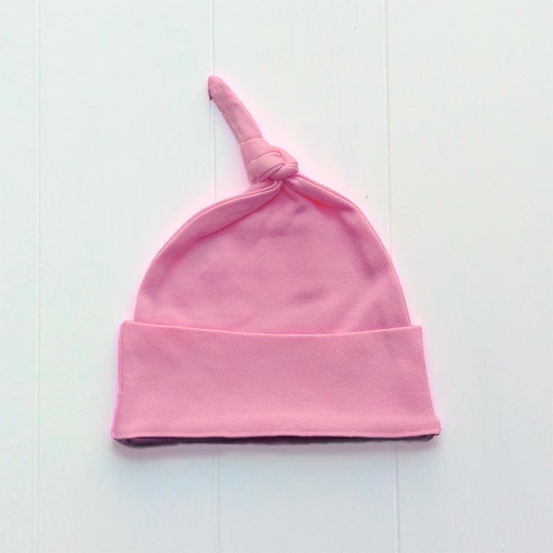 Newborn baby girls knotted hat in bright pink.  Suitable for ages 0-6 months and perfect to keep really little one's heads warm in the first few months. 100% super soft cotton and featuring a knotted top and turnover brim detail.