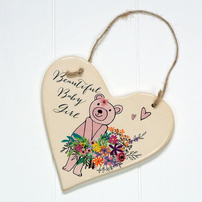 A beautiful sturdy ceramic hanging heart, that makes the perfect gift for any newborn little girl's bedroom..  From British brand Peel and Sardine, who are a boutique gift company based here in Leicestershire (just like us!). This heart features full colour gloss design and shows a bear holding a bunch of pink flowers.
